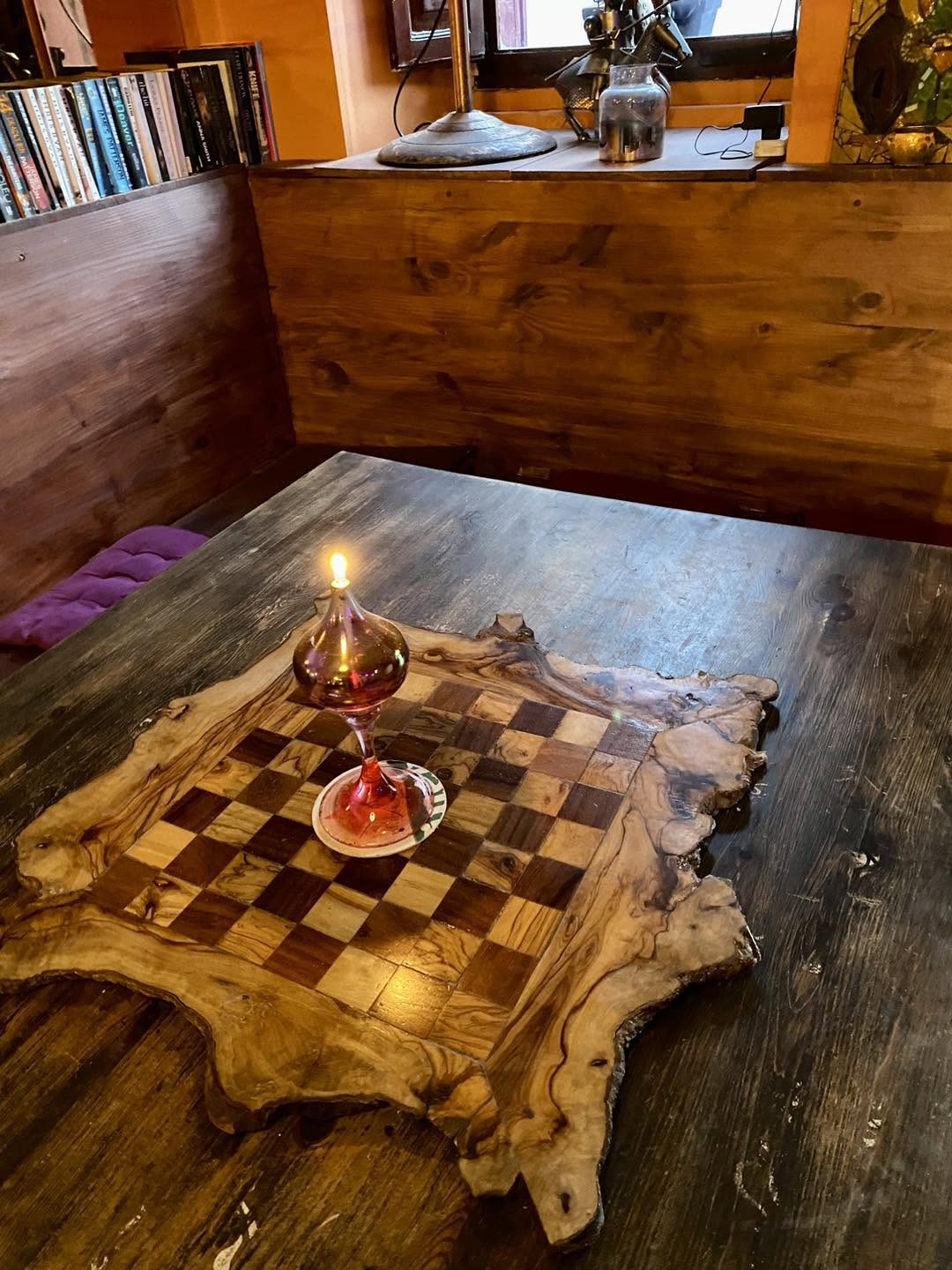 Handmade olive wood chess board and oil lamp on a table